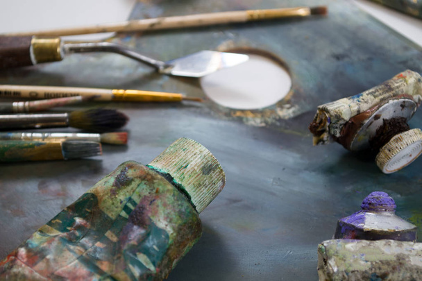 Pinturas al óleo brillantes en un tubo en una paleta sucia. Pinturas en uso
. - Foto, Imagen