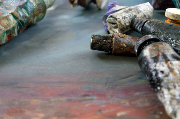 Pinturas al óleo brillantes en un tubo en una paleta sucia. Pinturas en uso
. - Foto, imagen