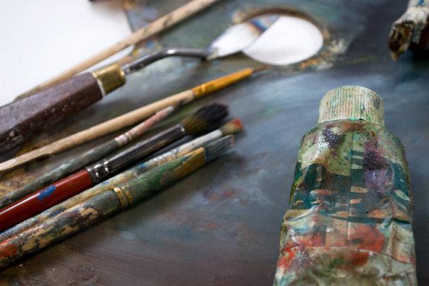 Bright oil paints in a tube on a dirty palette. Paints in use. - Photo, Image