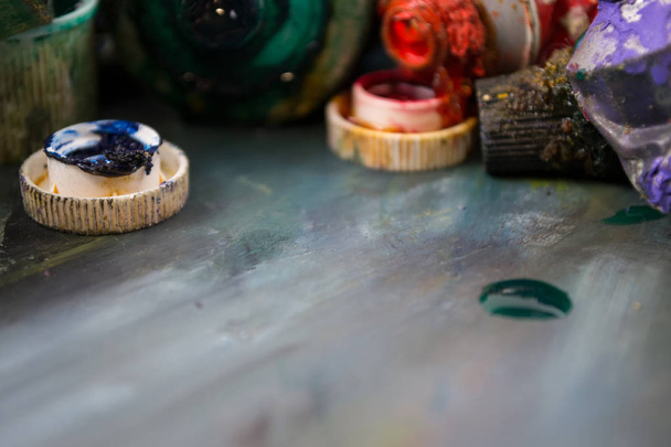 Fényes olajjal fest egy csőben, egy piszkos palettán. Festékek használata. - Fotó, kép