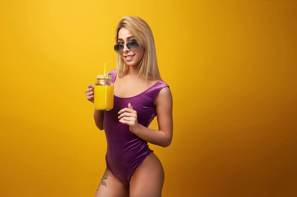 Alluring tattooed model with refreshing drink - Photo, image
