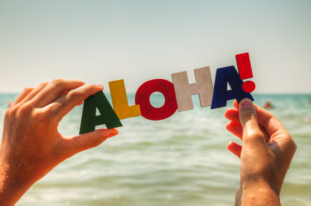 La mano de la hembra sosteniendo la palabra colorida 'Aloha'
 - Foto, Imagen