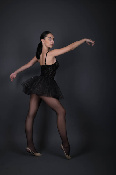 Balerina fekete ruhában pózol a stúdióban. - Fotó, kép
