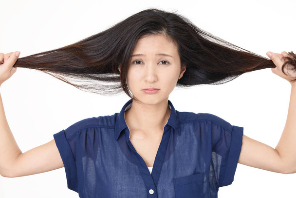 Vrouw op zoek ongelukkig met haar haren - Foto, afbeelding