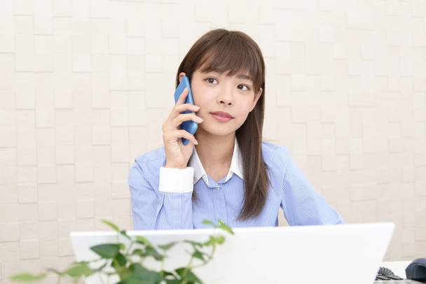 pracownik biurowy kobiece, który wykorzystuje inteligentny telefon  - Zdjęcie, obraz