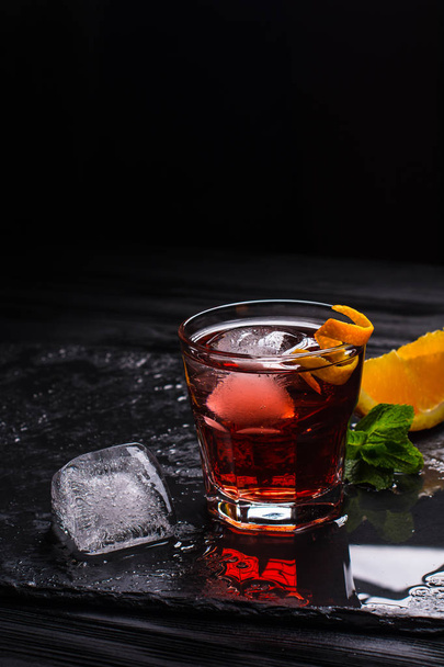 Mezcal Negroni cocktail. Smoky Italian aperitivo. Orange peel. - Zdjęcie, obraz