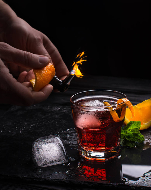 Mezcal Negroni cocktail. Smoky Italian aperitivo. Flamed orange peel. - Fotó, kép