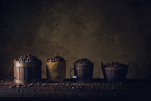 coffee beans in container on wood floor and old paper vintage aged background or texture. - Zdjęcie, obraz