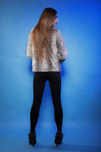 young woman in fur long hair blue background - Fotoğraf, Görsel