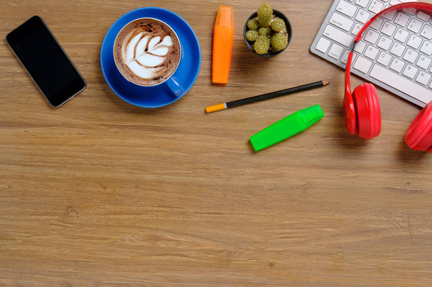 Офісні речі з клавіатурою, смартфоном, олівцем, навушниками та чашкою кави. Перегляд згори з простором для копіювання. Бізнес та концепція стратегії макет
. - Фото, зображення