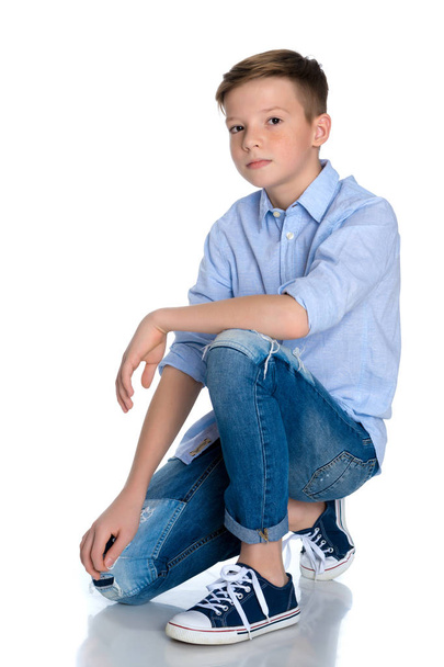 Fashionable boy teen sitting on the floor. - Φωτογραφία, εικόνα