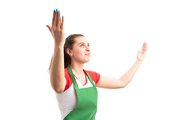 Incroyable jeune femme supermarché ou hypermarché employé souriant et levant les yeux avec les bras levés isolé sur fond blanc
 - Photo, image