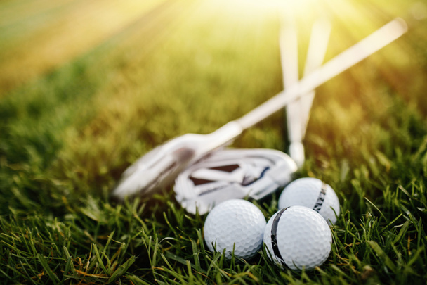 Golf balls and golf club  on green grass - Foto, imagen