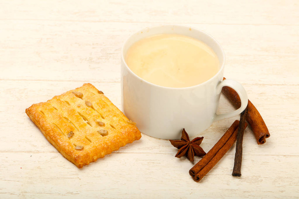 Koffie met gebak geserveerd met kaneel op houten tafel - Foto, afbeelding
