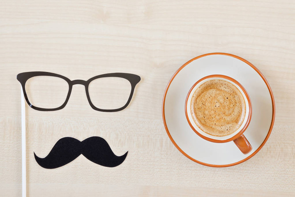 Mustache, glasses and cup of coffee on wooden background. Happy Father's day background. Greeting card - Foto, Bild