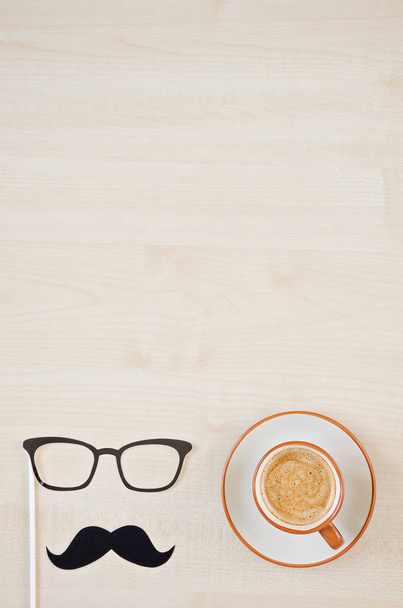 Mustache, glasses and cup of coffee on wooden background. Happy Father's day background. Copy space for inscription. Greeting card - Foto, afbeelding