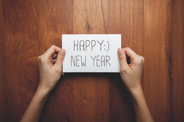 a woman with a sign in her hands with the words happy new year - Foto, imagen