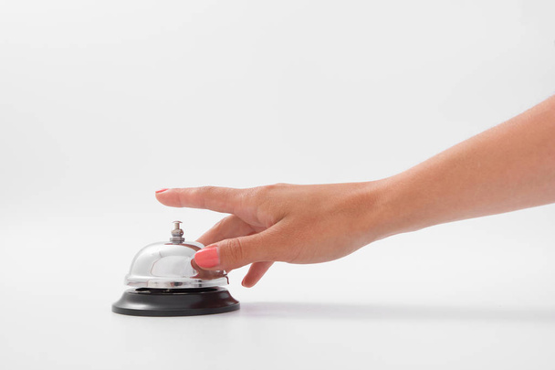 Mano de una mujer usando una campana de hotel aislada
 - Foto, imagen