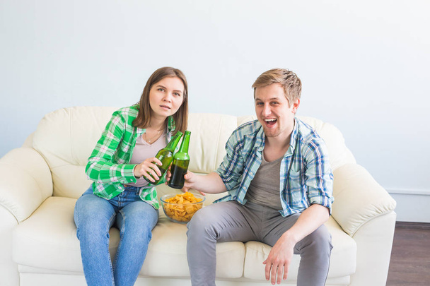 サッカー ワールド カップ コンセプト - テレビでスポーツの試合を見ながらソファに座っている友人のカップル - 写真・画像