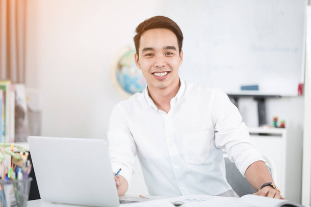 Jeune homme asiatique étudiant universitaire travaillant avec ordinateur portable et ordinateur portable, auto-apprentissage et les concepts de style de vie collège
 - Photo, image