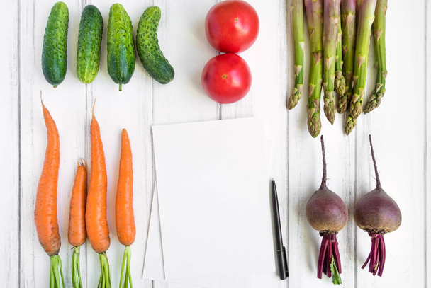 Bright vegetables and a cookbook, knolling composition on white background. Healthy food for salad. Flat lay, top view, view from above - Φωτογραφία, εικόνα
