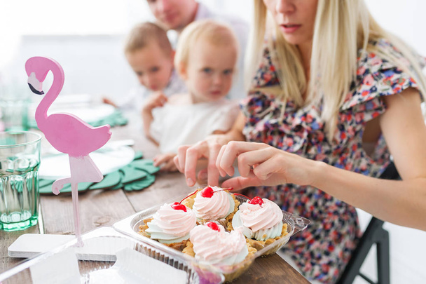 Sabrosos pasteles de cereza. Familia, madre, padre, hijo e hija caucásicos celebrando una fiesta de cumpleaños. Enfoque selectivo en pastel
 - Foto, Imagen