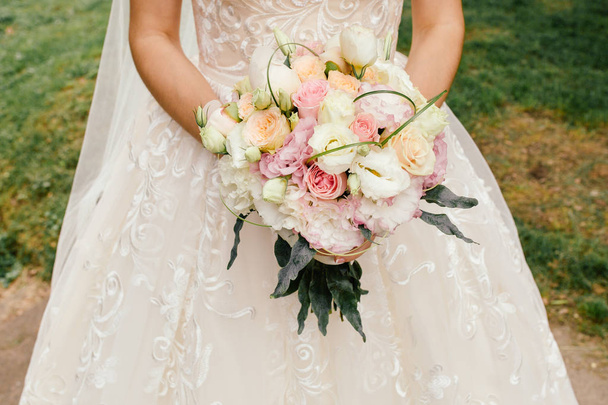 Beautiful wedding rustic bouquet with white roses. In bride hand - Foto, afbeelding