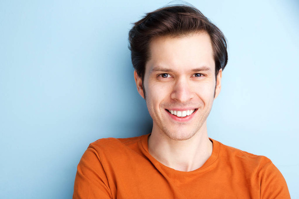 Close up retrato de homem feliz em camisa laranja no fundo azul
 - Foto, Imagem