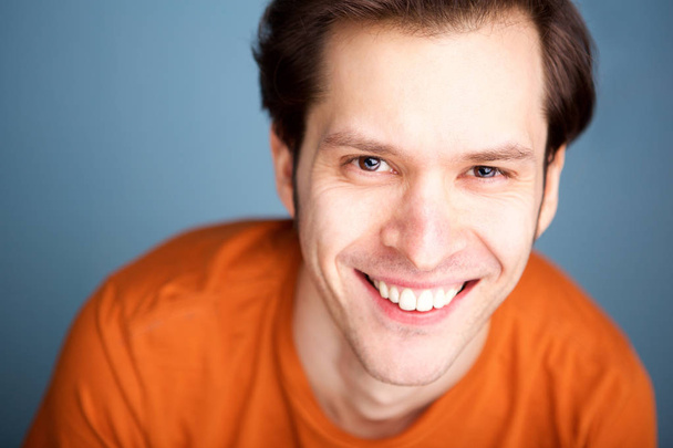 Close up portrait of fashionable man smiling on blue background - Photo, Image
