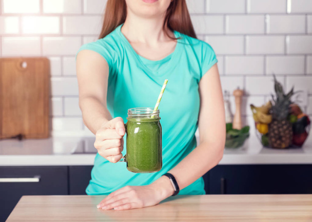Woman holding a glass jar of green smoothie close-up - Fotoğraf, Görsel
