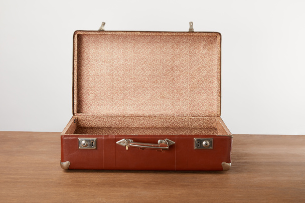 Open vintage suitcase on wooden table - Fotó, kép