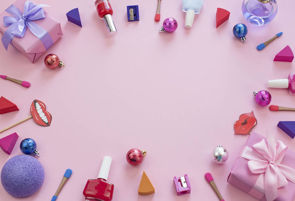 composición conjunto de cosméticos decorativos uñas pintalabios esmalte esponja sacapuntas caja regalo cinta satén arco fondo rosa
. - Foto, imagen
