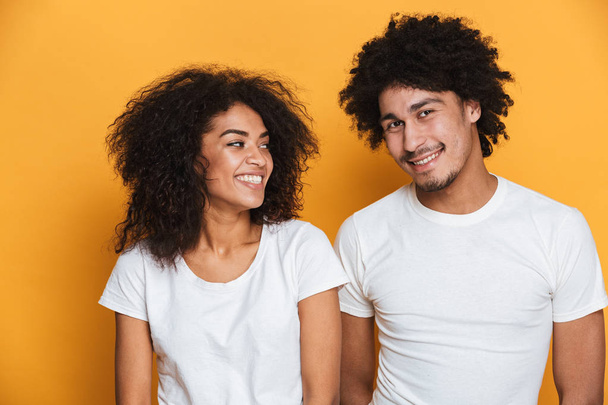 Portrait of a happy young afro american couple isolated over yellow background - Zdjęcie, obraz