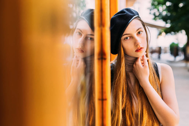 A gaze of a girl in a black cap with beautiful long hair - Foto, afbeelding