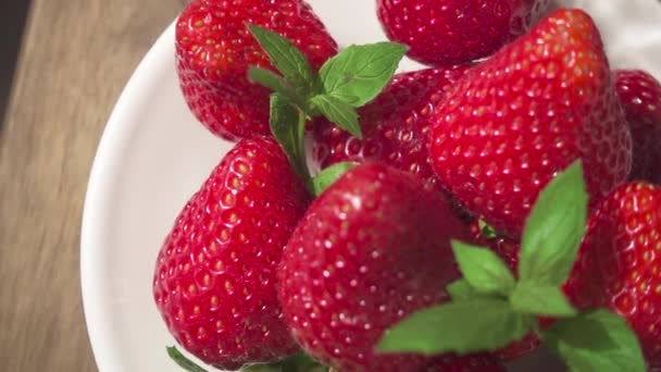 Slow motion strawberry on a plate and a glass with natural juice - Záběry, video