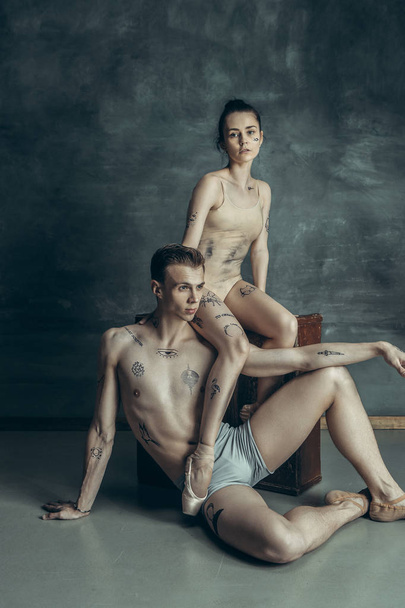 The young modern ballet dancers posing on gray studio background - Foto, immagini