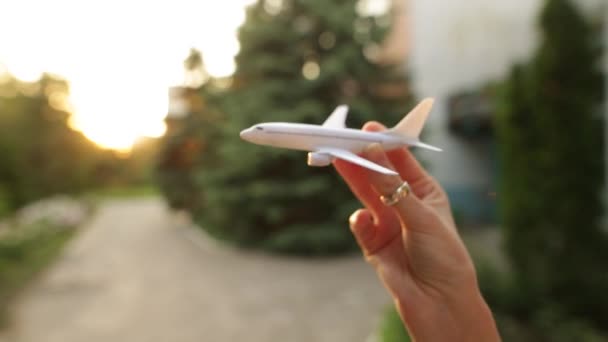 Speelgoed vliegtuig in de hand van de vrouw simuleert een vlucht. - Video