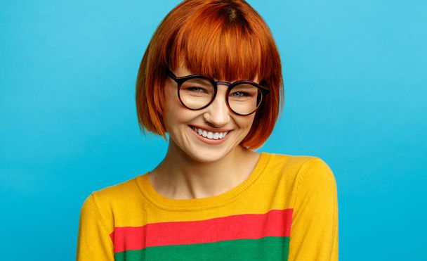 Portrait of beautiful smiling woman with red hair and glasses - Фото, зображення