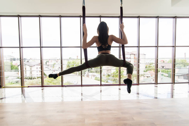 Fit молодая женщина делает yoga силы тяжести yoga asana растягивая упражнения в тренировке фитнеса студия чердак белого спортзала. Концепция здорового образа жизни. Копирование пространства
. - Фото, изображение