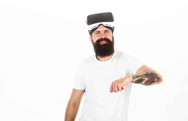 Man with beard and mustache holds VR glasses, white background. Hipster on smiling face use modern technologies for entertainment. VR technology concept. Guy with VR glasses or head mounted display - Photo, Image