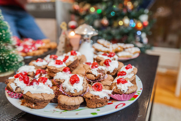 Boże Narodzenie deser serwujemy na stole, świeże choco babeczki z wiśni, domowe słodkości - Zdjęcie, obraz