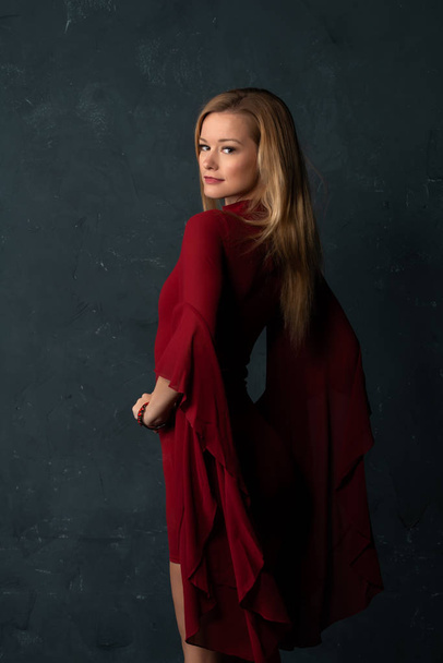 Tall slender blonde in a short red dress with voluminous sleeves - Fotografie, Obrázek