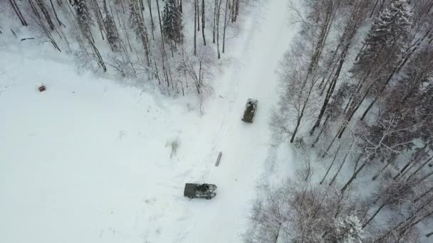 Askeri zırhlı personel taşıyıcı askeri tatbikatlar sırasında ormanda. Küçük. Askeri zırhlı personel taşıyıcıları kış ormanında üstten görünüm - Video, Çekim
