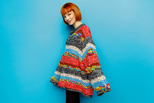Colorful photo of young female model wear oversize sweater isolated on blue background - Photo, Image