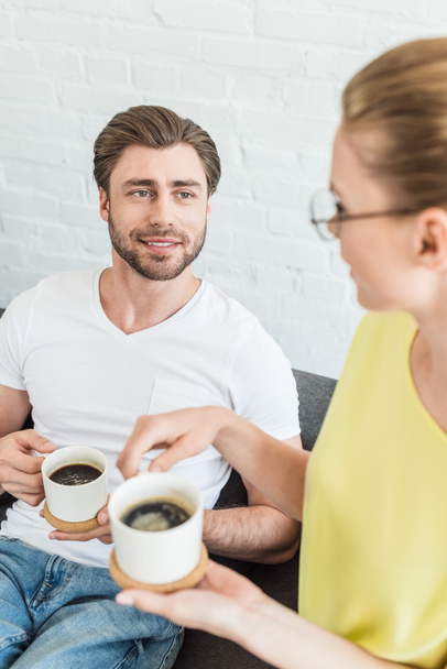 high angle view of young smiling couple with coffee cups at home  - Foto, immagini