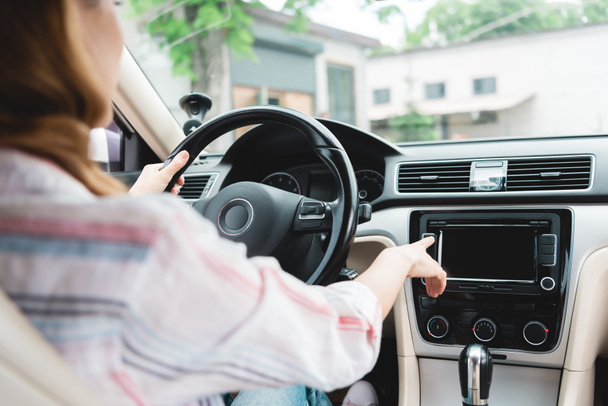 partial view of woman turning on radio while driving car - Photo, Image
