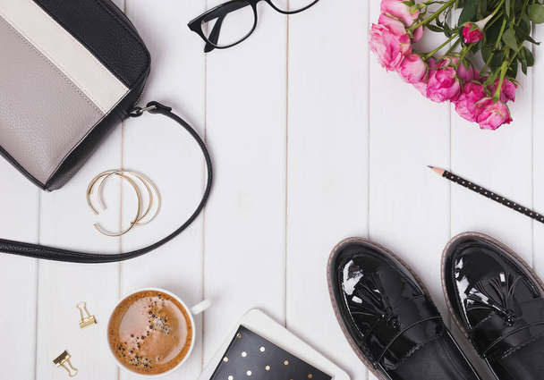 Feminine stylish accessories with loafers and bag, coffee and roses on the white table - Fotoğraf, Görsel
