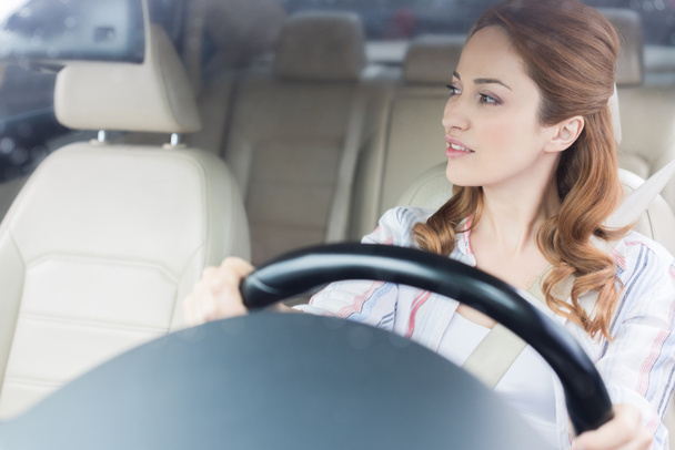 Portret van peinzende vrouw weg te kijken tijdens het auto rijden - Foto, afbeelding