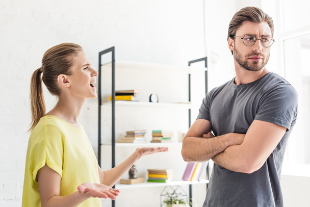 side view of woman yelling at boyfriend while she standing with crossed hands - Фото, зображення