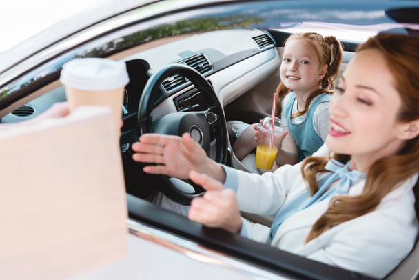valikoiva painopiste hymyilevä liikenainen ottaa pois järjestyksessä tyttären kanssa matkustajan istuin autossa
 - Valokuva, kuva